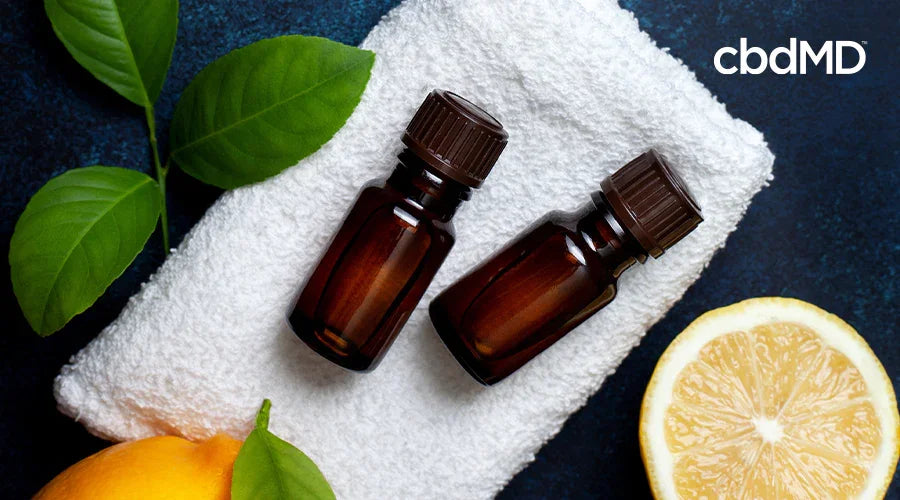 Essential oil bottles on a towel with lemon slices and green leaves for stress relief