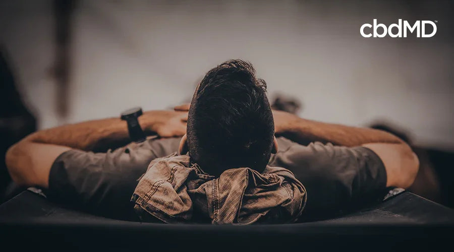 Man relaxing on a cot, hands behind head, promoting restful sleep and relaxation
