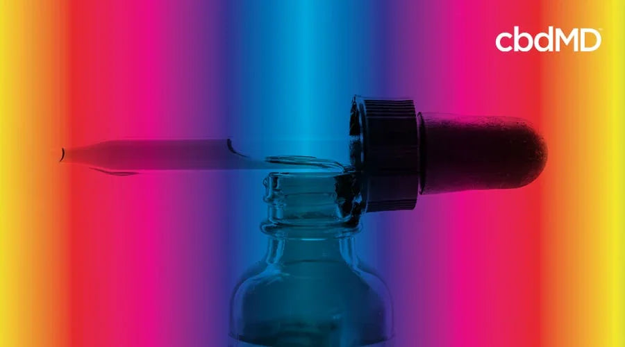 RSO dropper resting on top of a tincture bottle with a gradient background