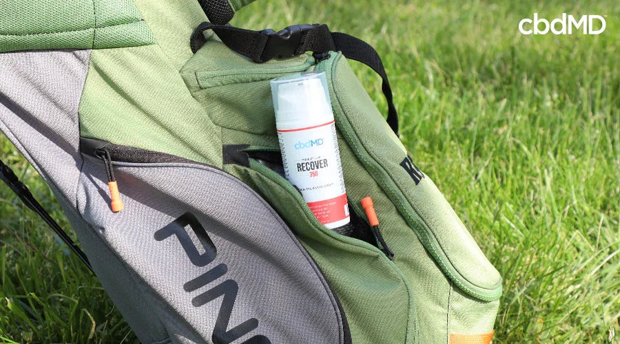 CBD recovery cream in green golf bag pocket on grass, outdoor sports wellness support