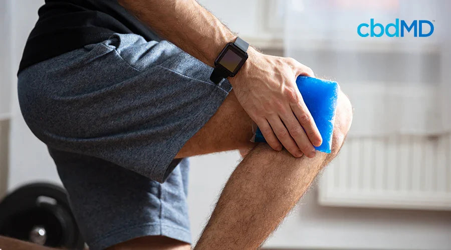 Athlete icing sore knee with ice pack, fitness recovery, injury prevention at home