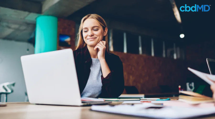 woman looking at a laptop and smiling 
