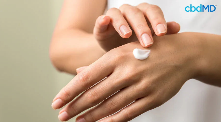 Person Applying Pain Relief Cream with CBD to Hands