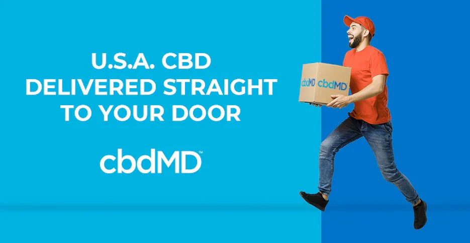 Smiling delivery man in red shirt and cap holding cbdMD package against blue background, promoting CBD delivery.