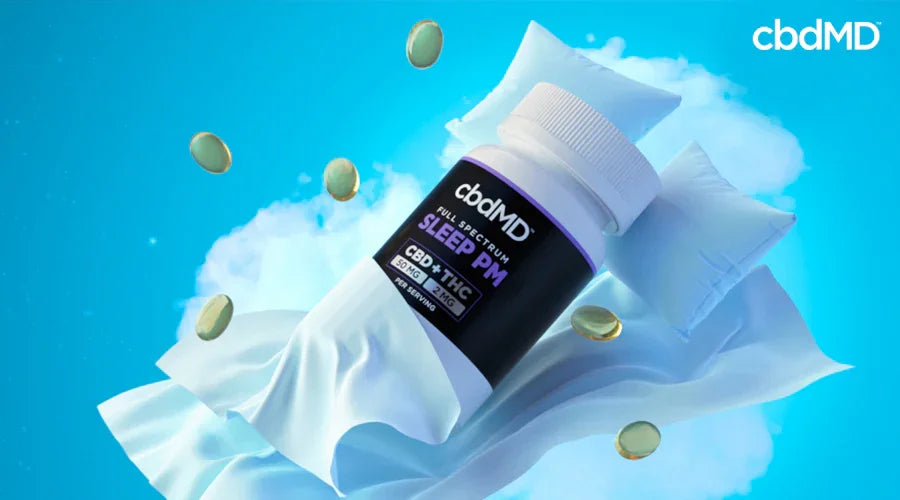 CBD sleep supplement bottle on pillows with capsules, blue sky background