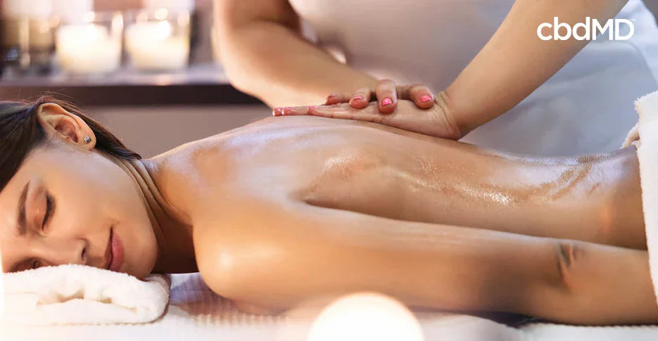 Woman relaxing during professional back massage in spa with calming candlelight ambiance