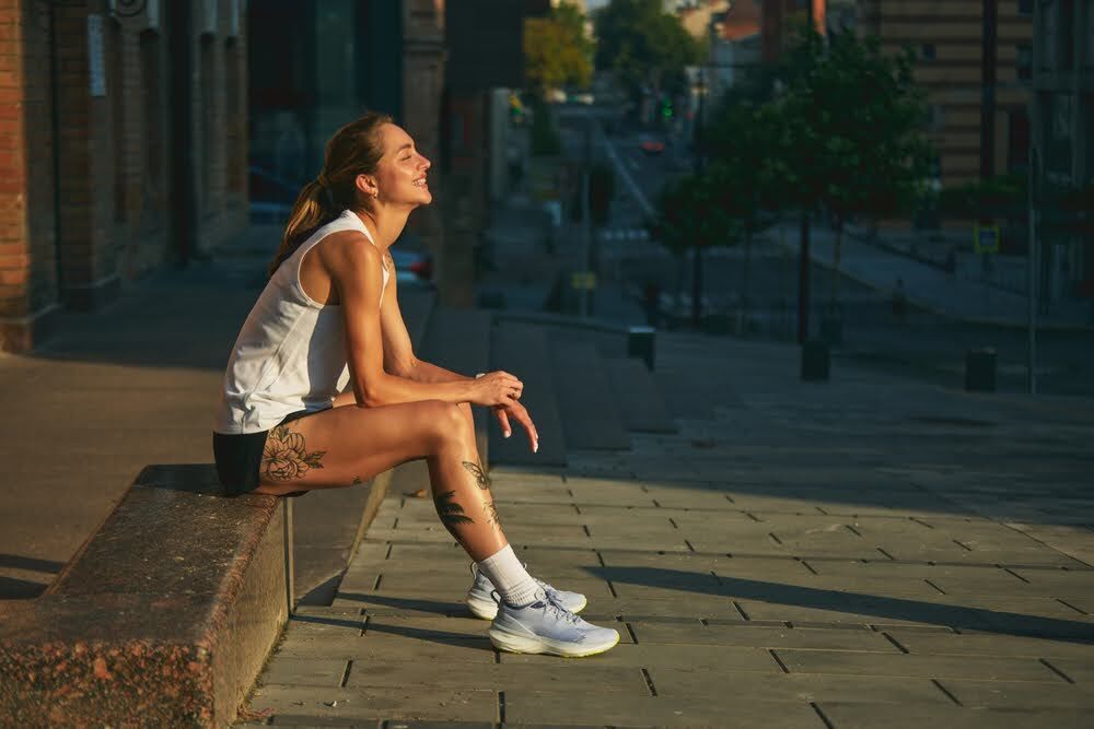 woman sitting on a concrete bench after a run