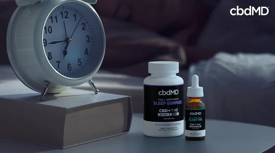 Full spectrum sleep gummies 50 mg cbd 2 mg thc raspberry and sleep pm tincture mint on a nightstand with an alarm clock - cbdMD