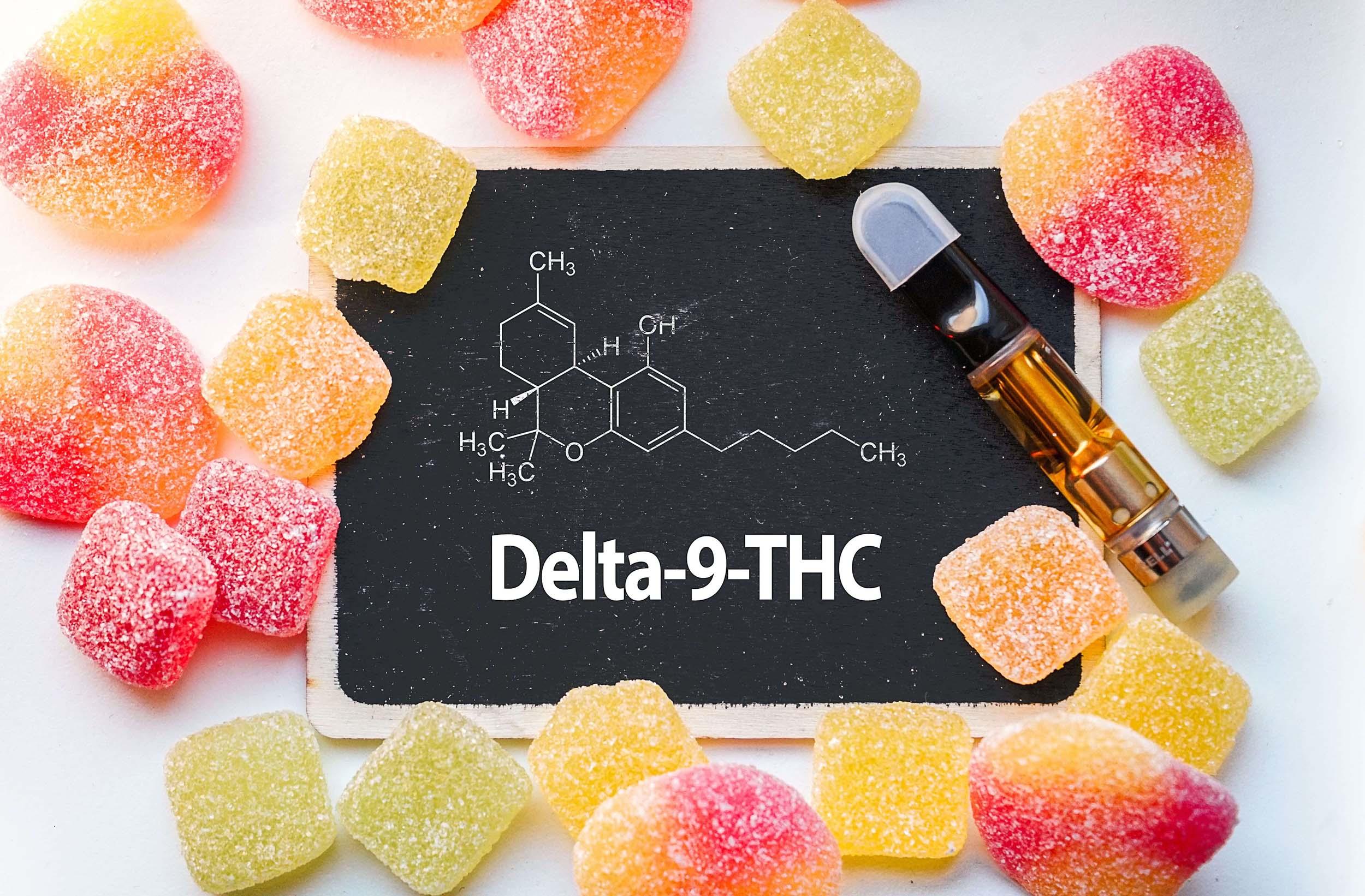 Delta-9-THC chalkboard with molecular diagram, assorted gummies, and vape cartridge