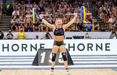 Annie Thorisdottir holding a large weight above her head