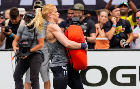 athlete Annie Thorisdottir carrying a large orange weight